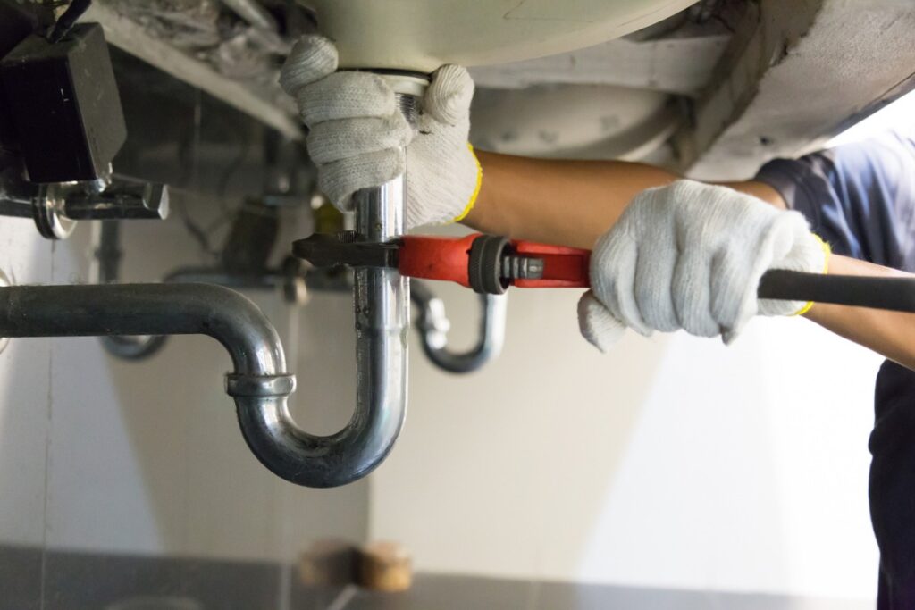 Plumbing 2 plumber fixing white sink pipe with adjustable wrench picture id1150199946